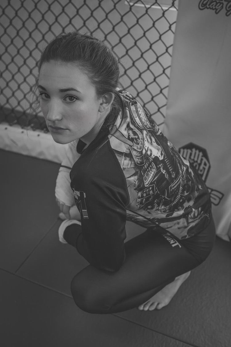 Black and white portrait of Brianna Kristin crouched in the gym