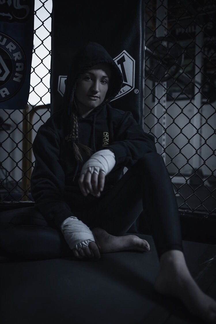 Brianna Kristin sitting in the corner with hands wrapped